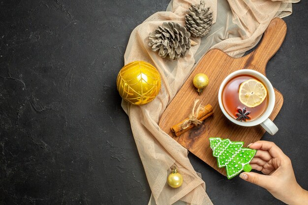 tasse de thé noir avec accessoires de décoration citron et cannelle limes sur planche à découper en bois
