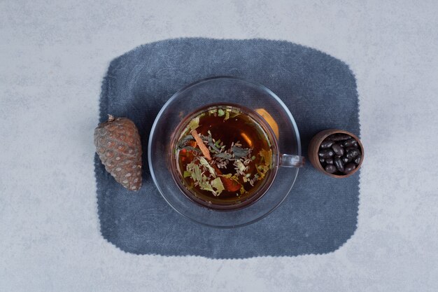 Tasse de thé, pomme de pin et grains sur fond de marbre. Photo de haute qualité