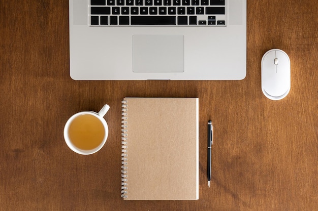 Photo gratuite une tasse de thé et une souris d'ordinateur sur une table en bois