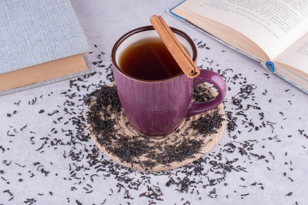 Tasse de thé sur table en marbre avec cannelle et livres. photo de haute qualité