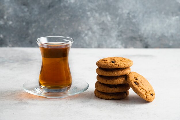 Une tasse de thé en verre avec de délicieux biscuits.