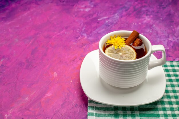 Tasse à thé vue de dessus sur une serviette verte avec du citron et de la cannelle