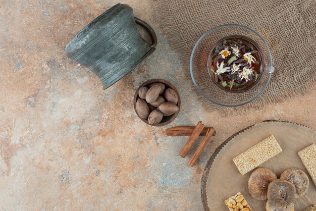 Une tasse de tisane avec une bouilloire ancienne et des brittles aux arachides