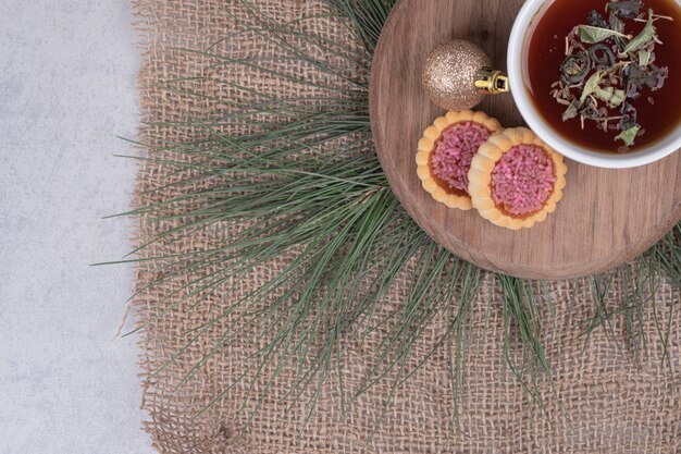 Tasse de tisane, boule de Noël et biscuits sur plaque en bois. Photo de haute qualité