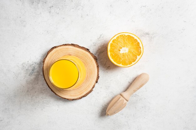 Une tasse en verre de jus de fruits frais avec une tranche d'orange.