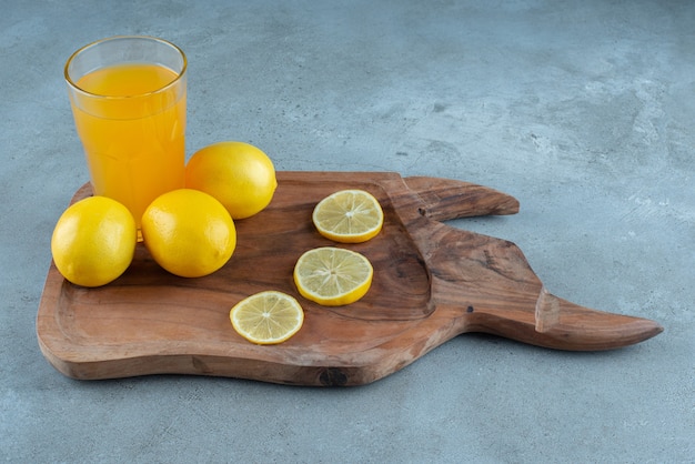 Une tasse en verre de jus d'orange avec des citrons frais.