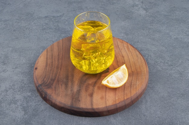 Une tasse en verre de limonade avec des glaçons et des tranches de citron