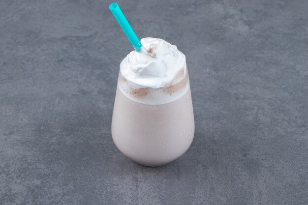 Une tasse en verre de milkshake sucré avec de la crème fouettée. photo de haute qualité