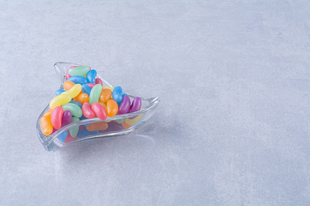 Photo gratuite une tasse en verre pleine de bonbons aux haricots colorés