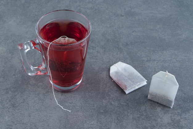 Une tasse en verre de thé de rose musquée sur du marbre.