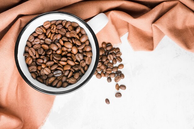 Tasse vue de dessus avec grains de café torréfiés