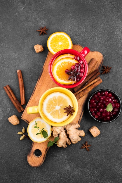 Tasses avec arôme de fruits de thé sur planche de bois