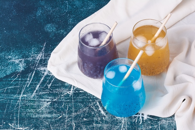 Tasses de boisson triple couleur sur bleu.