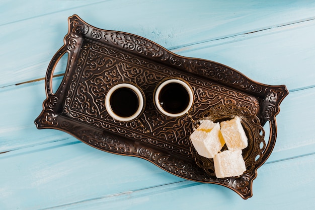 Photo gratuite tasses de café près de soucoupe avec sucrerie turque sur un plateau