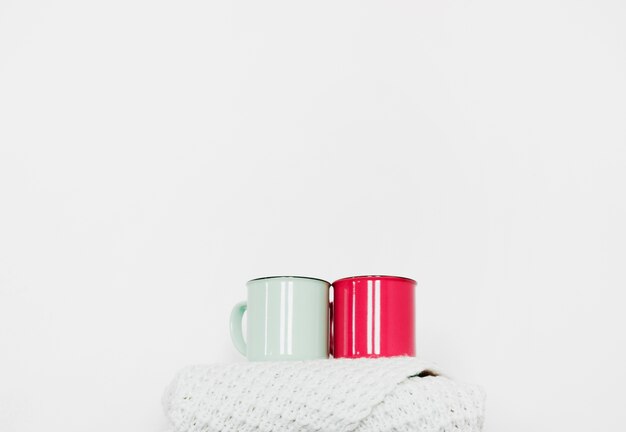 Photo gratuite tasses debout sur une écharpe chaude