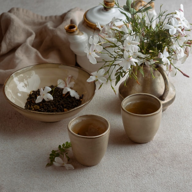 Photo gratuite tasses à thé à angle élevé et belles fleurs