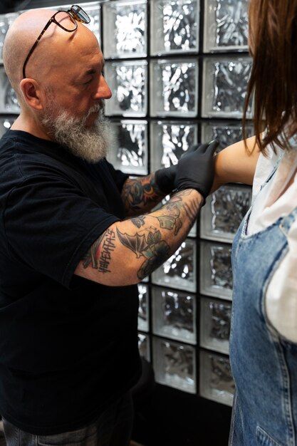 Tatoueur expérimenté travaillant sur le tatouage du client