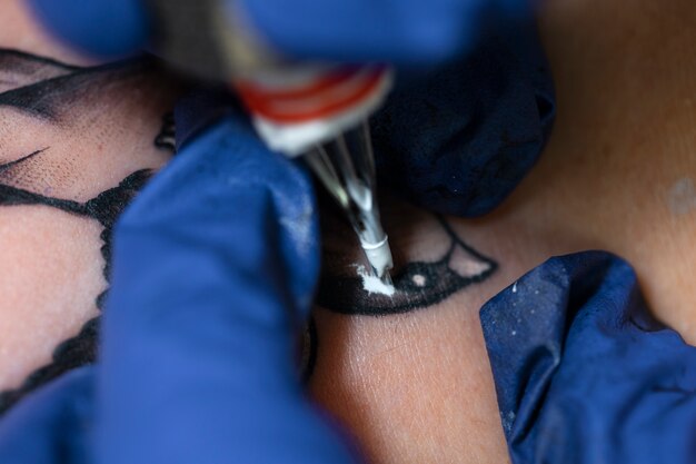 Tatoueur expérimenté travaillant sur le tatouage du client