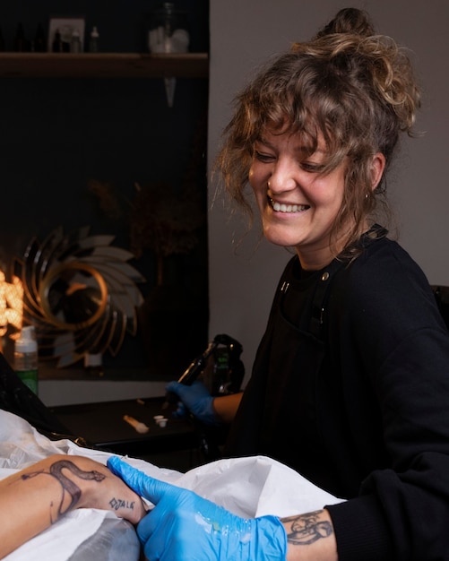 Photo gratuite tatoueur faisant son travail plan moyen