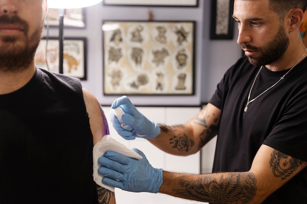 Photo gratuite tatoueur talentueux faisant son travail vue latérale