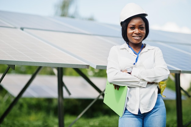 Un technicien afro-américain vérifie l'entretien des panneaux solaires Une ingénieure noire à la station solaire