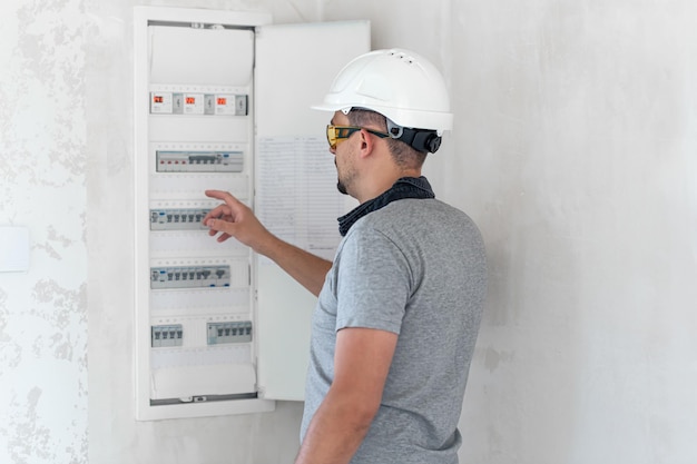 Photo gratuite technicien en électricité à l'air concentré tout en travaillant dans un standard avec des fusibles