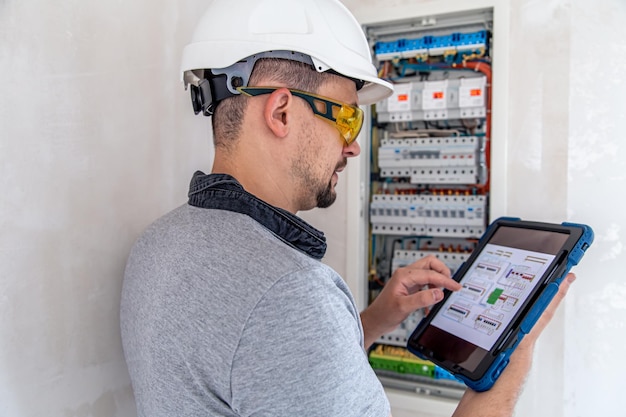 Photo gratuite technicien en électricité à l'air concentré tout en travaillant dans un standard avec des fusibles