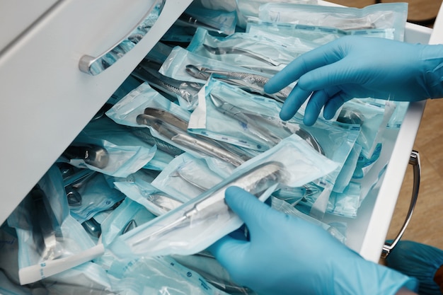 Technicien de laboratoire médical tenant un ensemble d'instruments jetables stériles