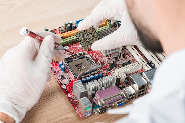 Technicien mâle, insertion, puce, dans, carte mère ordinateur, sur, bois, bureau