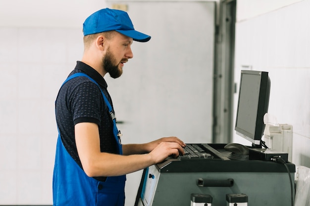 Technicien en train de taper sur le clavier du garage