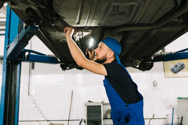 Photo gratuite technicien vérifiant le fond du véhicule