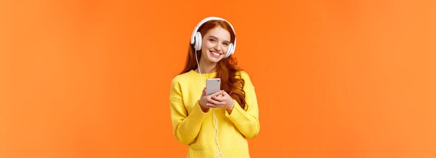 La technologie shopping et les gens concept modern cute hipster redhead girl wearing white headphones hol