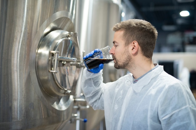 Technologue dégustant un verre de boisson et en vérifiant la qualité