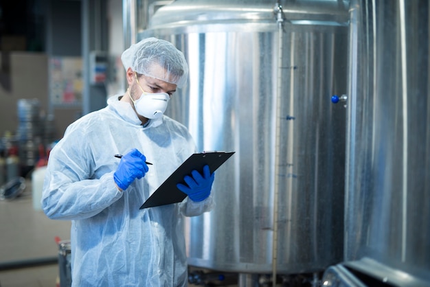 Technologue expert contrôlant la production dans une usine de transformation pharmaceutique ou alimentaire