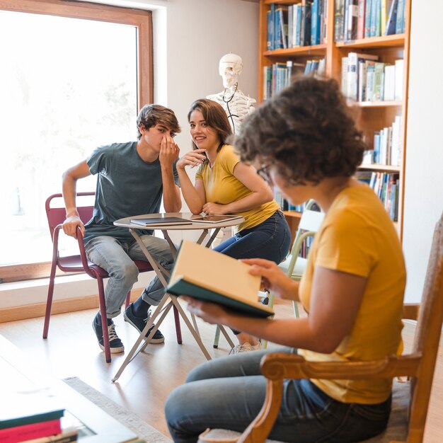 Teen couple bavardant à propos de camarade de classe