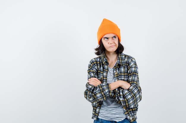 Teen femme en chemise à carreaux et bonnet gesticulant isolé