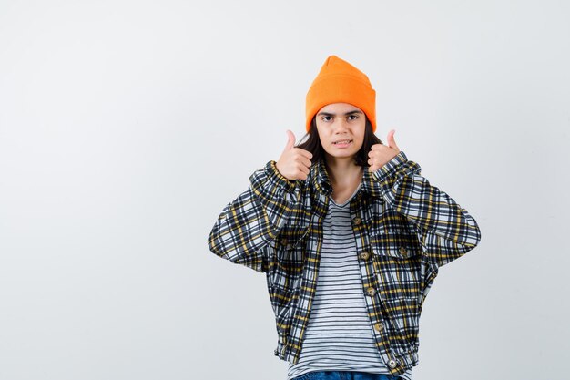 Teen femme en chemise à carreaux et bonnet gesticulant isolé