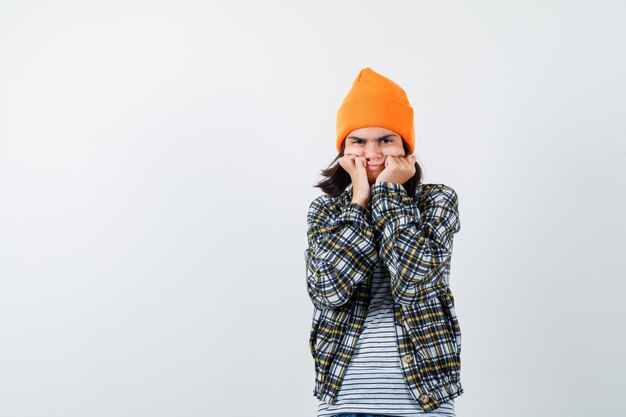 Teen femme en chemise à carreaux et bonnet gesticulant isolé