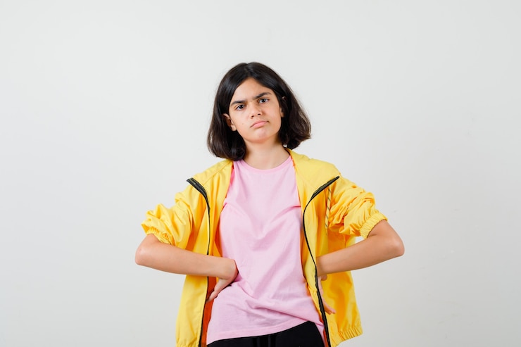 Photo gratuit teen girl holding bras sur la taille en t-shirt, veste et à la pensive. vue de face.