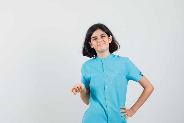 Teen girl posant comme exprimer son opinion en chemise bleue et à la jolie