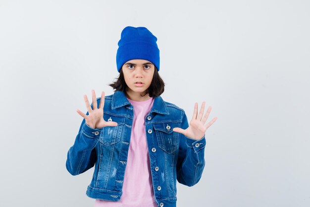 Teen woman levant les mains en abandon posent à la peur