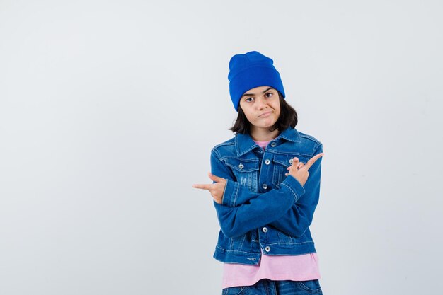 Teen woman pointant des directions opposées avec l'index en t-shirt rose à l'accent