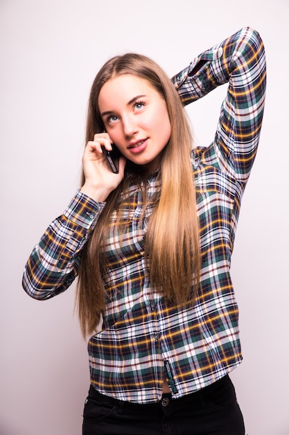 Téléphone femme heureuse parler. Visage avec sourire à pleines dents, isolé sur mur blanc