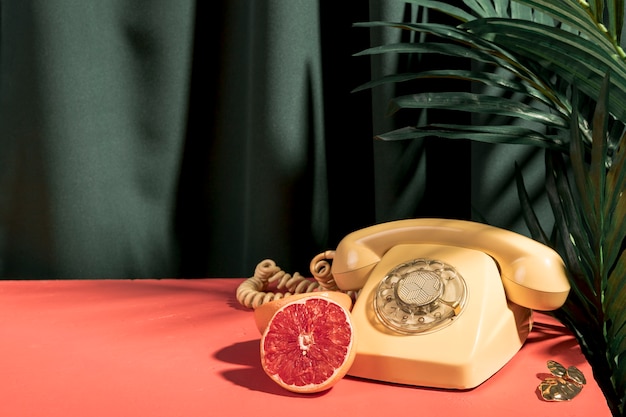 Téléphone jaune à côté de pamplemousse sur la table