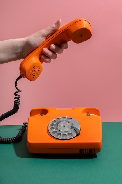 Téléphone orange sur table verte grand angle