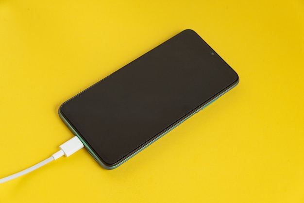 Téléphone portable vert connecté au câble USB type C - Chargement