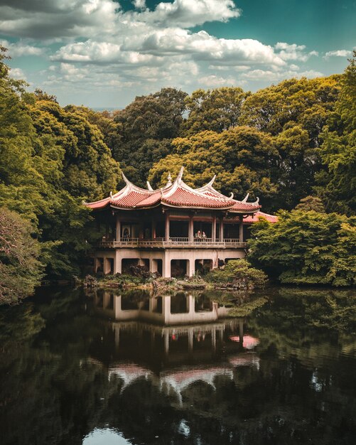 Temple bouddhiste sur le lac entouré d'arbres, jardin national de Shinjuku Gyoen, Tokyo