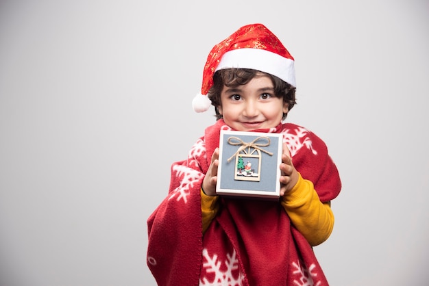 Temps de Noël avec un enfant adorable tenant une boîte-cadeau