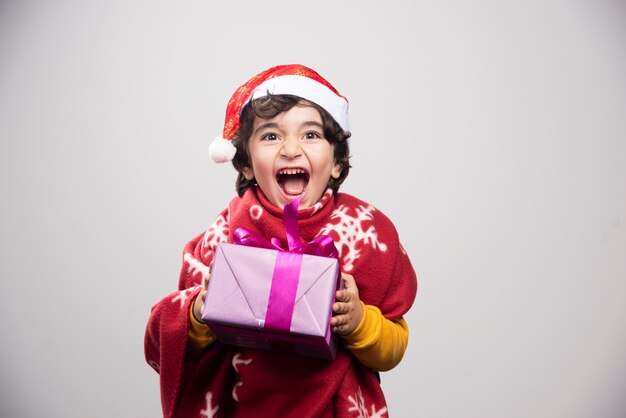 Temps de Noël avec un enfant heureux tenant une boîte-cadeau