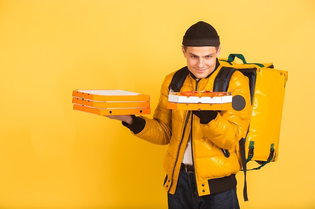 Photo gratuite tenant des boîtes à pizzas. émotions du livreur caucasien sur jaune